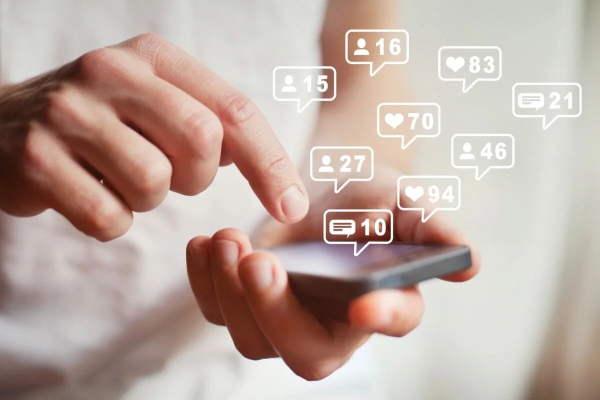 Personne consultant un réseau social sur un smartphone avec des symboles de sécurité numérique