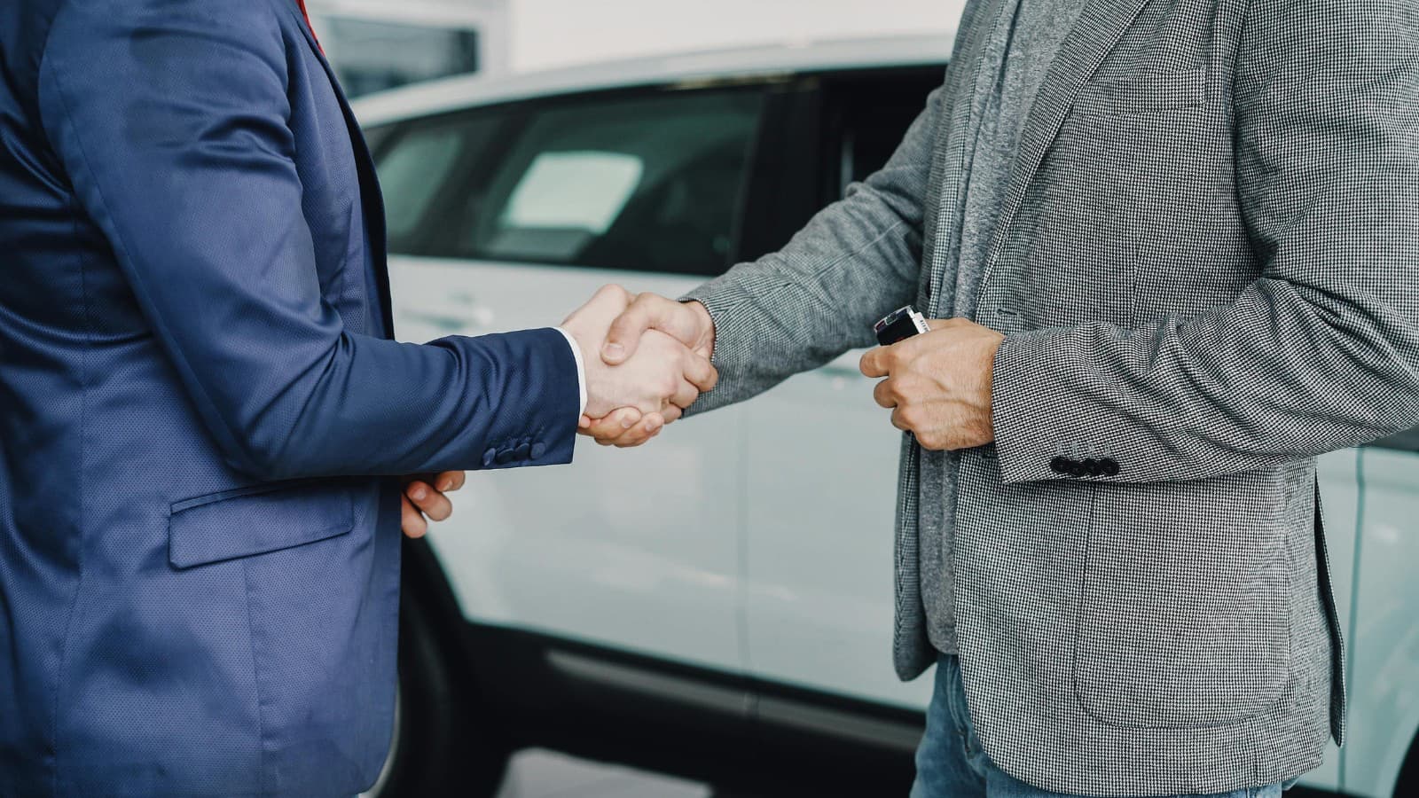 Courtier en automobile remettant les clés d'une voiture neuve à un client